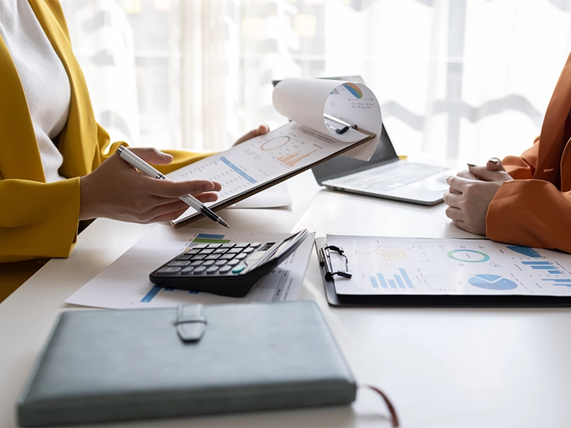 business women working on desk office with using a calculator to calculate the numbers tax, finance accountingresearch or financial strategy in company concept